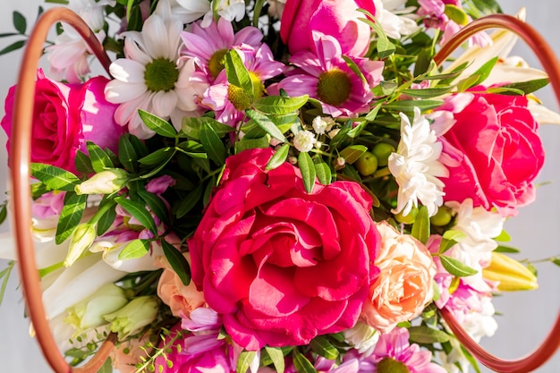 Prachtig lenteboeket in een papieren mandje met hengsels. Regeling met verschillende bloemen.