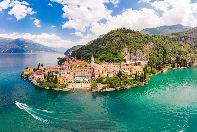 Prachtig luchtfoto panoramisch uitzicht vanaf de drone naar de beroemde oude Italiaanse stad Varenna aan de oever van het Comomeer Hoog bovenaanzicht naar het waterlandschap met groene heuvels, bergen en stad in zonnige zomerdag