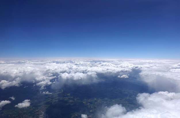 Prachtig luchtlandschap met uitzicht vanuit het vliegtuig boven dichte witte wolken hoog in de stratosfeer