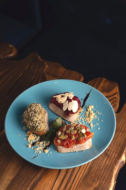 Prachtig opgediende vegetarische bruschetta gemaakt van rode biet, tomaat, hummus met oker en zaden