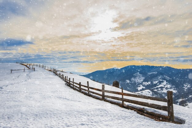 Prachtig panorama van de bergketens bedekt met sneeuw en verdeeld in wandelpaden met uitzicht op de bewolkte hemel en zonsondergang. Plaats voor reclame. Bergtoerisme concept