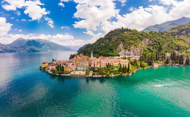 Foto prachtig panoramisch luchtfoto van de drone naar de beroemde oude stad varenna aan de oever van het comomeer hoog bovenaanzicht op waterlandschap met groene heuvels, bergen en stad in zonnige zomerdag