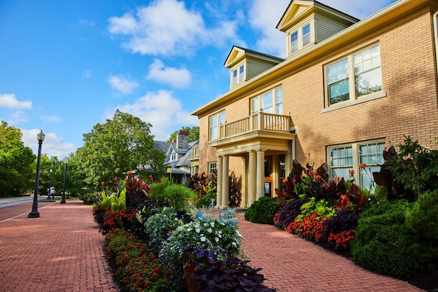 Prachtig rood bakstenen pad op gerefinancierd geel huis met hypotheek op huis of appartement bloementuin