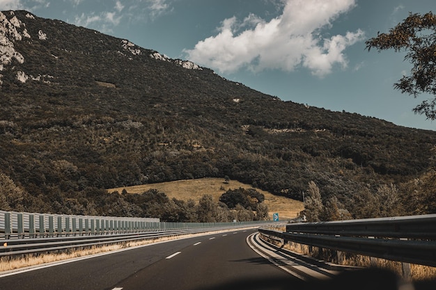 Prachtig schilderachtig landschap op bergen bedekt met bossen Uitzicht vanuit het autoraam op een moderne en hoogwaardige snelweg