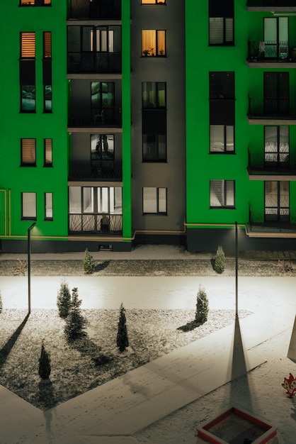 Prachtig terras in een kleurrijk groen appartementencomplex сovered in sneeuw.