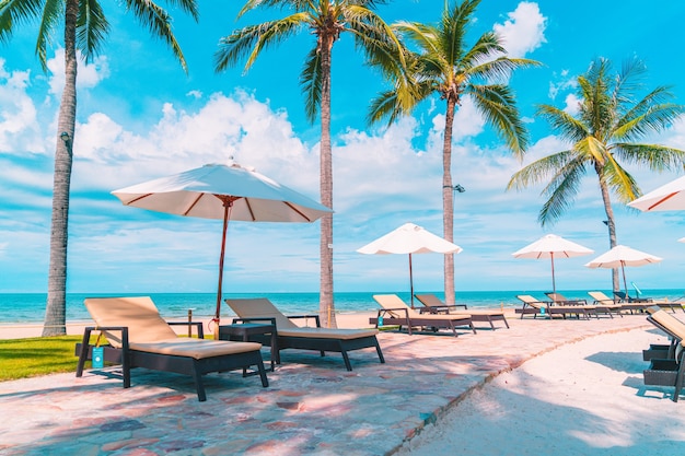 Prachtig tropisch strand en zee met parasol en stoel rond zwembad in hotelresort voor reizen en vakantie