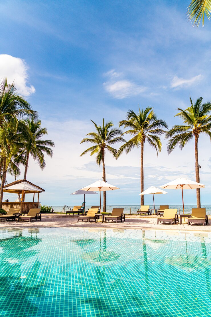 Foto prachtig tropisch strand en zee met parasol en stoel rond zwembad in hotelresort voor reizen en vakantie