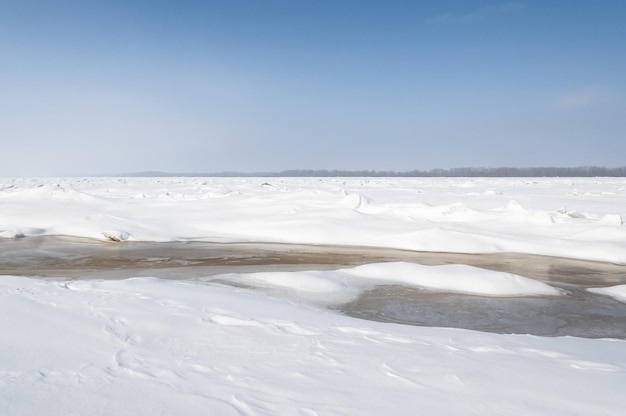 Prachtig uitzicht op de bevroren rivier bedekt met brokken ijs en witte berijpte sneeuw besneeuwde woestijn