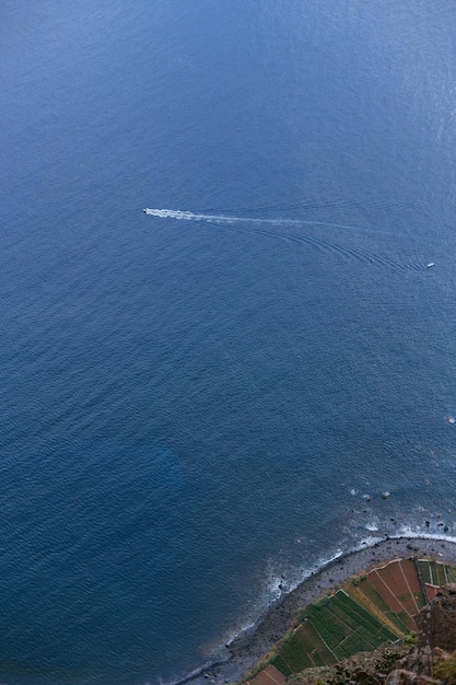 Prachtig uitzicht op de oceaan met het jacht en het strand met uitzicht op de rotsen vanaf het skywalk-observatiedek boven het prachtige eiland Madeira