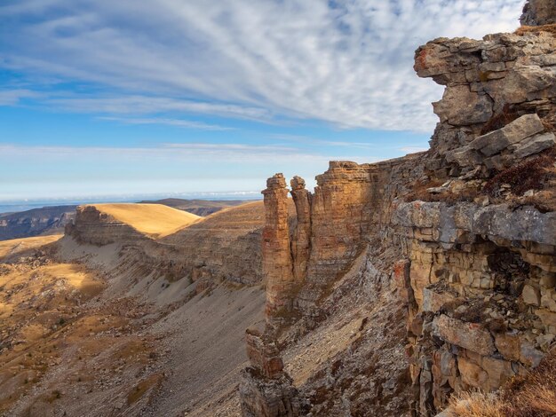 Prachtig uitzicht op de rotsen van het Bermamyt-plateau op zonnige dag Kaukasus-gebergte aan de rand van een klif in de verte Sfeervol landschap met silhouetten van bergen KarachayCherkessia Rusland