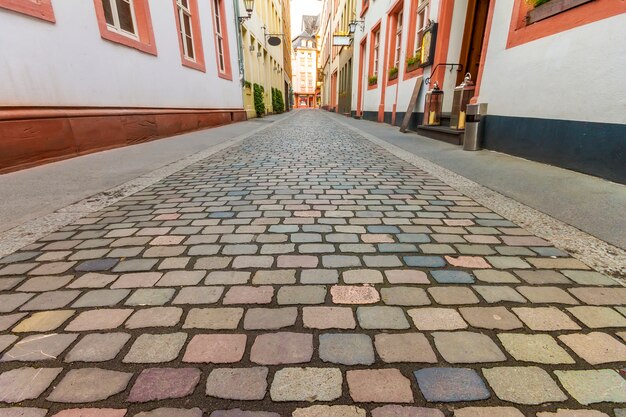 Prachtig uitzicht op de schilderachtige smalle straat met historische traditionele huizen en geplaveide straat in een oude stad in europa met blauwe lucht en de wolken in de zomer