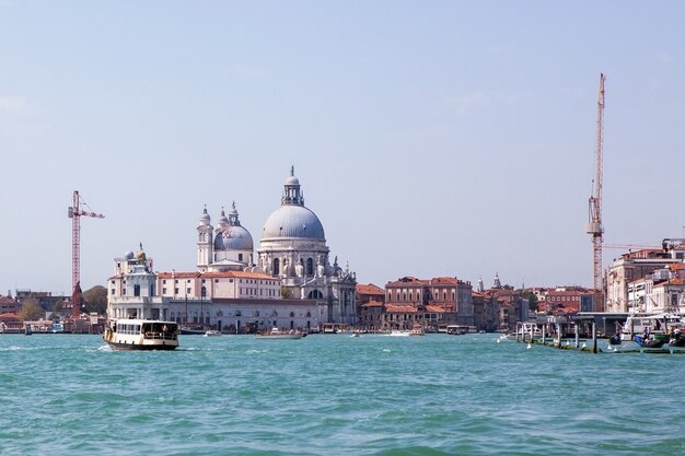 Prachtig uitzicht op de traditionele gondel op het beroemde Canal Grande met Basilica di Santa Maria della Salute in prachtig licht bij zonsondergang in Venetië, Italië.