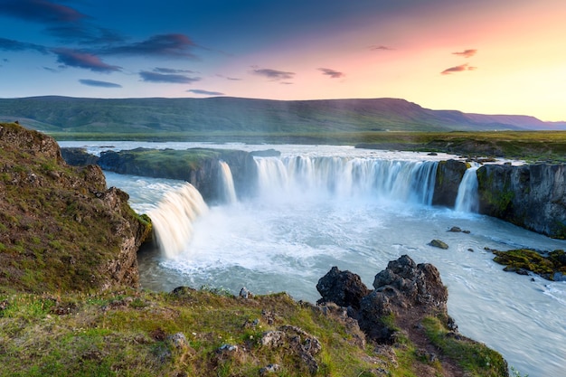 Prachtig uitzicht op de zonsondergang over de krachtige Godafoss-waterval die in de zomer uit de rivier de Skjalfandafljot stroomt in het noorden van IJsland