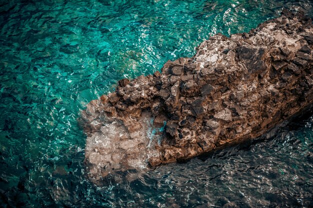 Prachtig uitzicht op grote klif in golvende turquoise zee