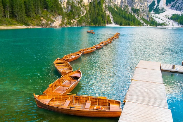 Foto prachtig uitzicht op het meer van braies met houten boten en dolomieten italië