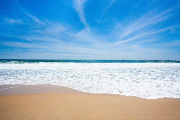 Prachtig uitzicht op oceaangolven die over strandzand spoelen op een warme zomerdag