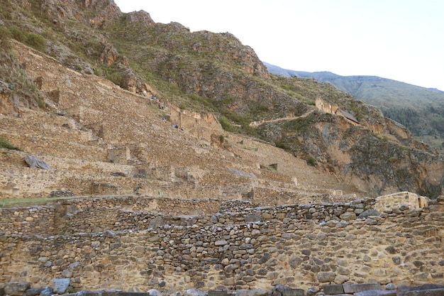 Prachtig uitzicht op Ollantaytambo met groepen bezoekers die klimmen op de Inca-ruïnes in Urubamba, Peru