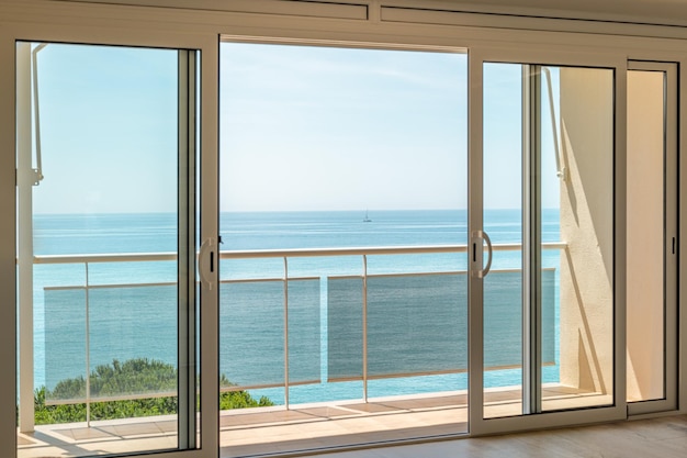 Prachtig uitzicht vanuit de hotelkamer door het panoramische raam naar de zee op een zonnige warme zomerdag