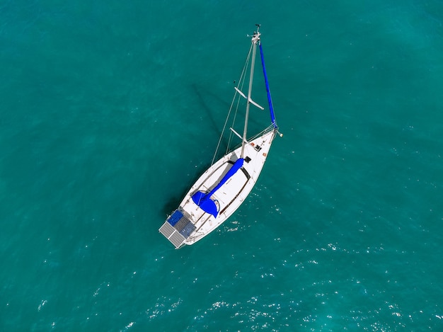 Prachtig uitzicht vanuit de lucht van een enorm wit en blauw jacht dat over de blauwe lagune vaart