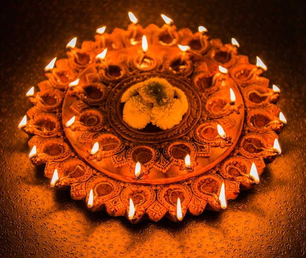 Prachtig verlicht terracotta Diwali diya bord in de nacht, sfeerverlichting, selectieve focus