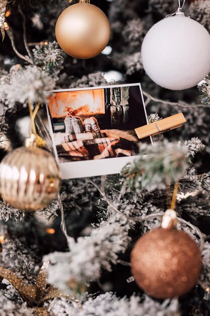 Prachtig versierde besneeuwde kerstboom met ballen en foto's