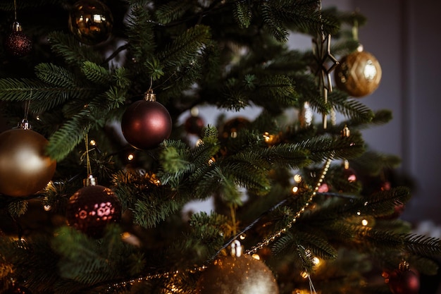 Prachtig versierde kerstboom close-up Vrolijke lichten van slingers op een kerstboom in een donkere kamer