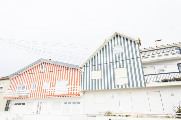 Prachtig vintage houten gestreept huis vlakbij een weg met auto's in Portugal Prachtig vissersdorp met creatieve architectuur Vakantie aan zee