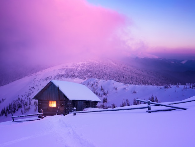 Prachtig winterlandschap met berghuis in de sneeuw