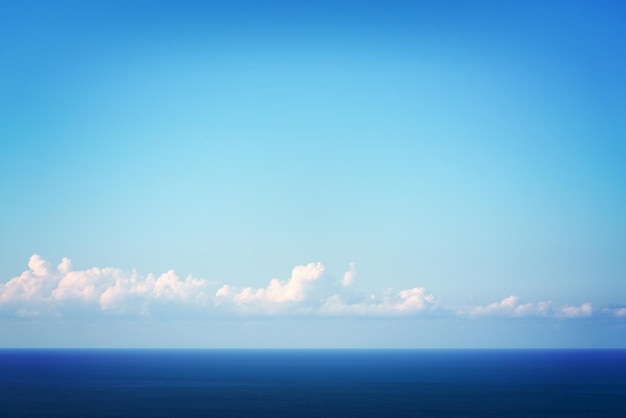 Prachtig zeegezicht blauw kalm water en lucht met witte wolken