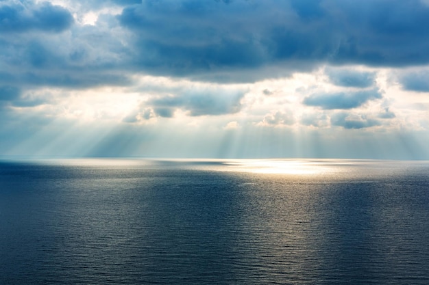 Foto prachtig zeegezicht van blauwe zee, balken van zonlicht en lucht met wolken