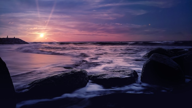 Prachtig zonsondergangstrand met rotsen