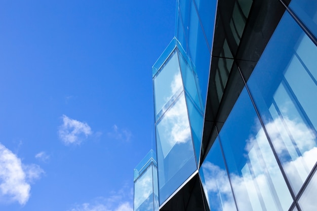 Prachtige architectuur zakelijke kantoorgebouw met vensterglas patroon in de wolkenkrabber stad. wolken worden weerspiegeld in de glazen gevel van het gebouw.