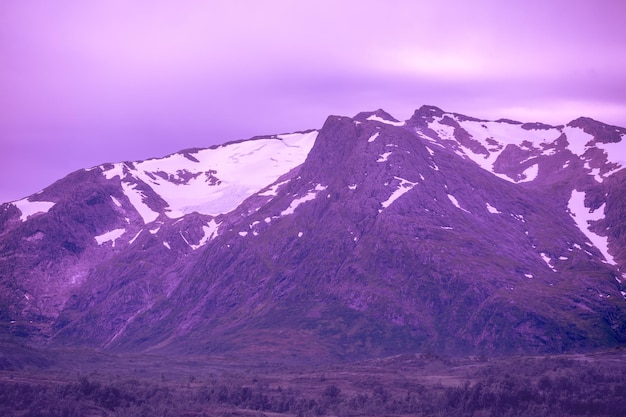 Prachtige bergen bedekt met sneeuw tegen een avondrood in trendy Velvet Violet kleur