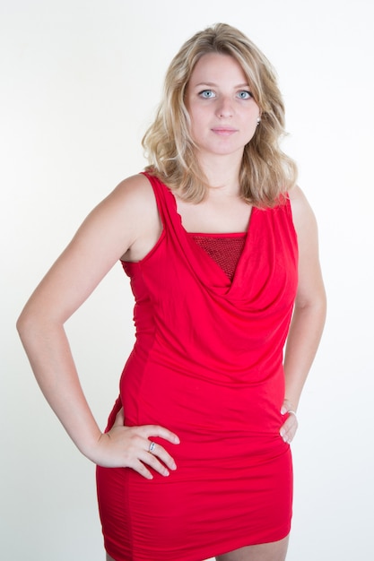 Prachtige blonde jonge vrouw met een elegante rode jurk