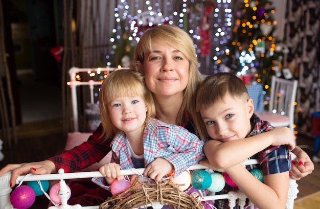 Foto prachtige familie in new year's kleren, knuffelen, plezier maken in huis