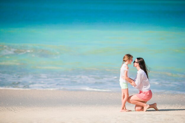 Prachtige familie van moeder en meisje op strandvakantie