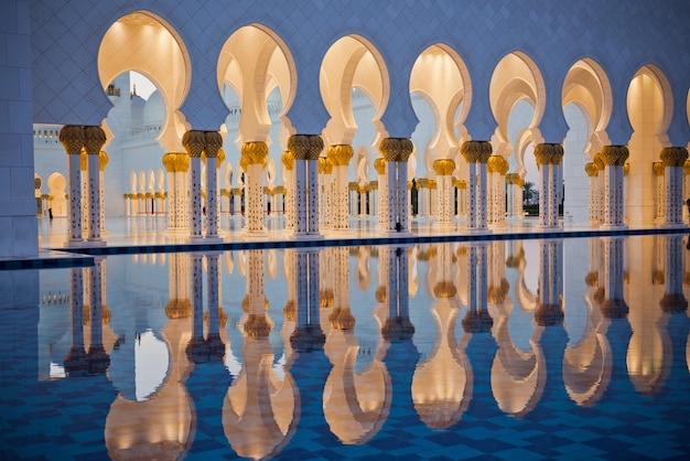 Prachtige galerij van de beroemde Sheikh Zayed White Mosque in Abu Dhabi, Verenigde Arabische Emiraten. Reflecties bij zonsondergang