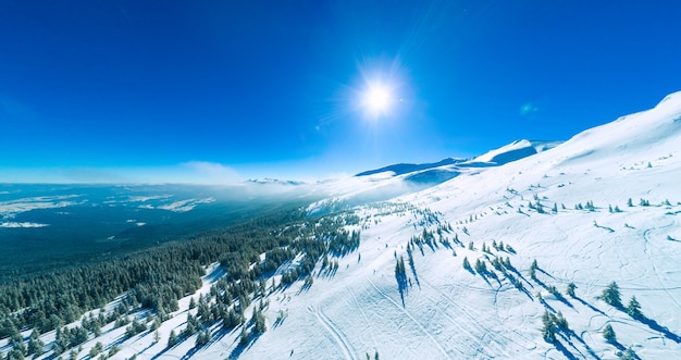 Prachtige gigantische sneeuwlaag op de heuvels in de bergen bedekt met sneeuw op een zonnige ijzige winterdag