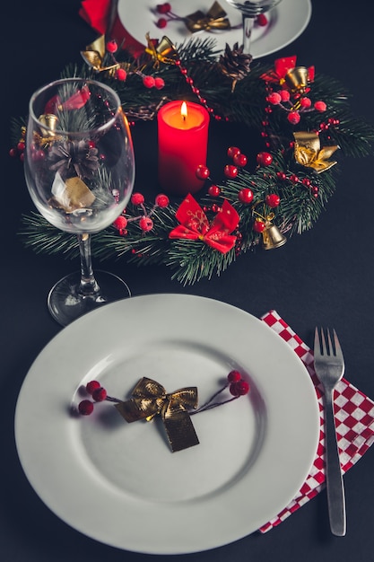 Prachtige kerstdiner couvert voor twee. Tafel versierd met een krans en een kaars.