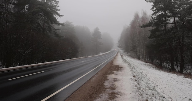 prachtige met sneeuw bedekte weg tijdens mist in de winter