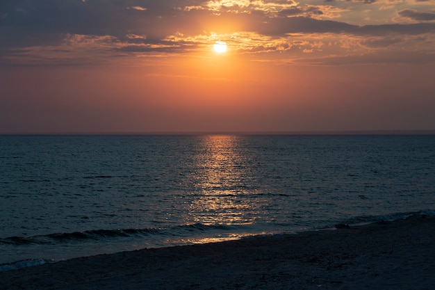 Prachtige ondergaande zon met wolken boven de zee, landschap.