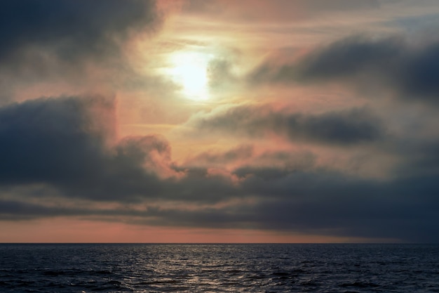 Prachtige rode zonsondergang, donkere wolken en de Atlantische Oceaan aan de horizon