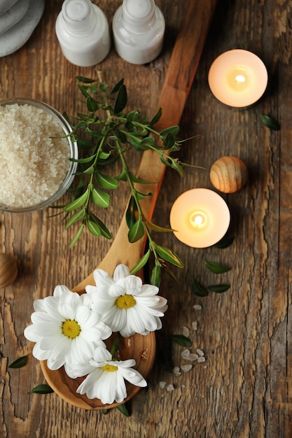Prachtige spa-compositie met bloemen en kaarsen op houten tafel