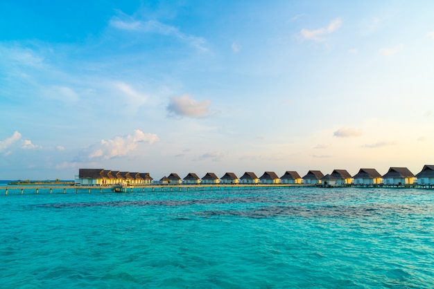 Prachtige tropische zonsondergang over eiland van de Maldiven met water bungalow in hotel resort