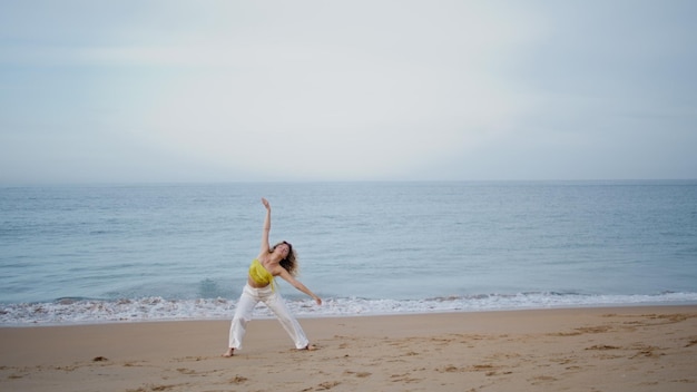 Prachtige vrouw die aan de kust danst zomer avond jonge choreograaf bewegend lichaam