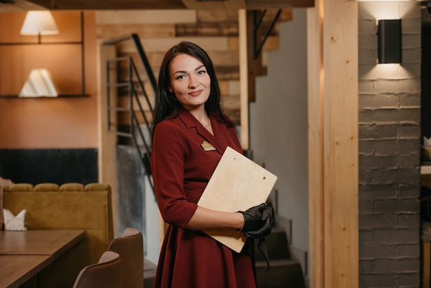 Prachtige vrouwelijke restaurantmanager in zwarte wegwerphandschoenen