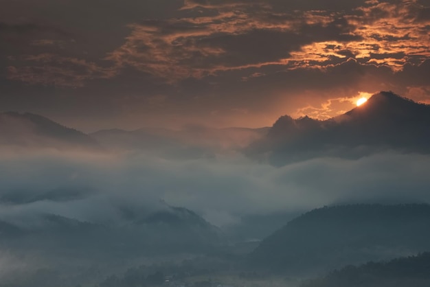 Prachtige zee van mist in een vallei met oranje luchtwolk in een zonsopgangtijd