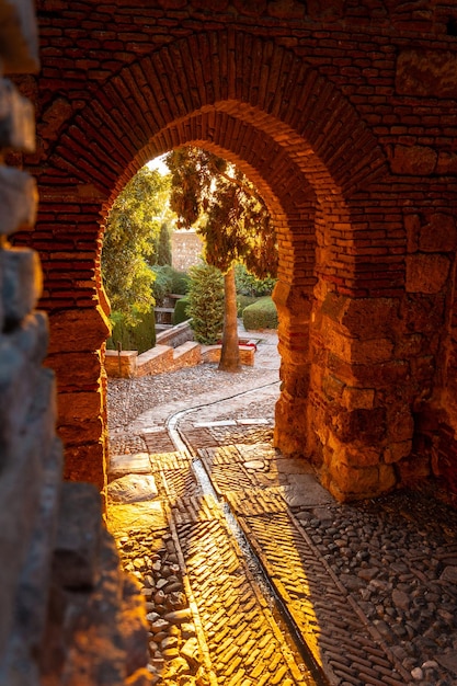 Prachtige zonsondergang bij de poort van de muur en de tuinen van het Alcazaba in de stad Malaga, Andalusië. Spanje. Middeleeuws fort in Arabische stijl