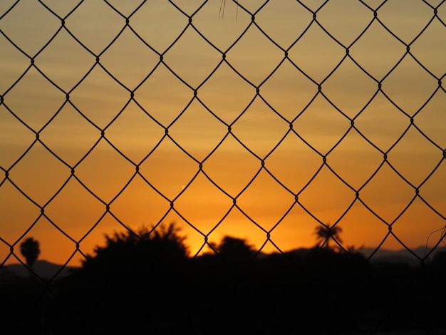 Prachtige zonsondergang door de draadomheining