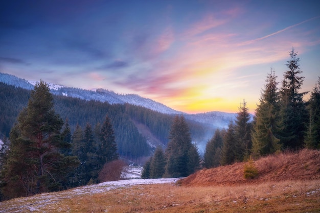 Prachtige zonsondergang in de bergen Kleurrijk landschap met met sneeuw bedekte bergen